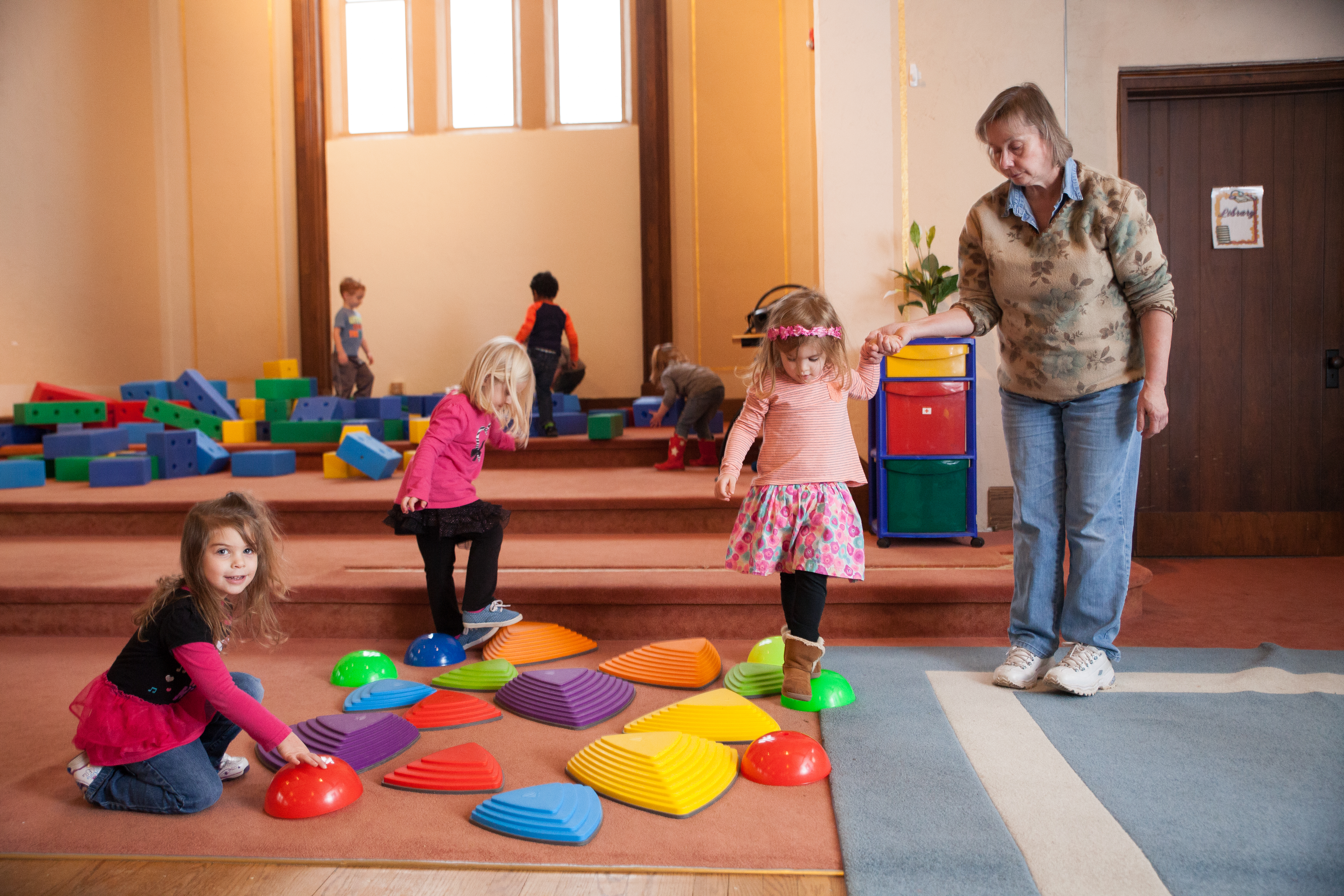 children play in large playroom at Community Child Care Center