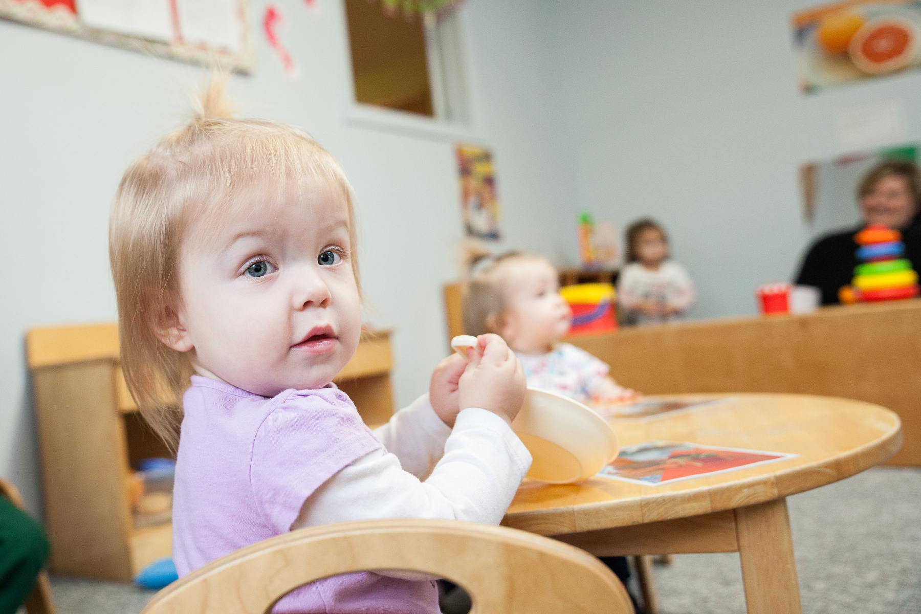 child sits at table at Community Child Care Center